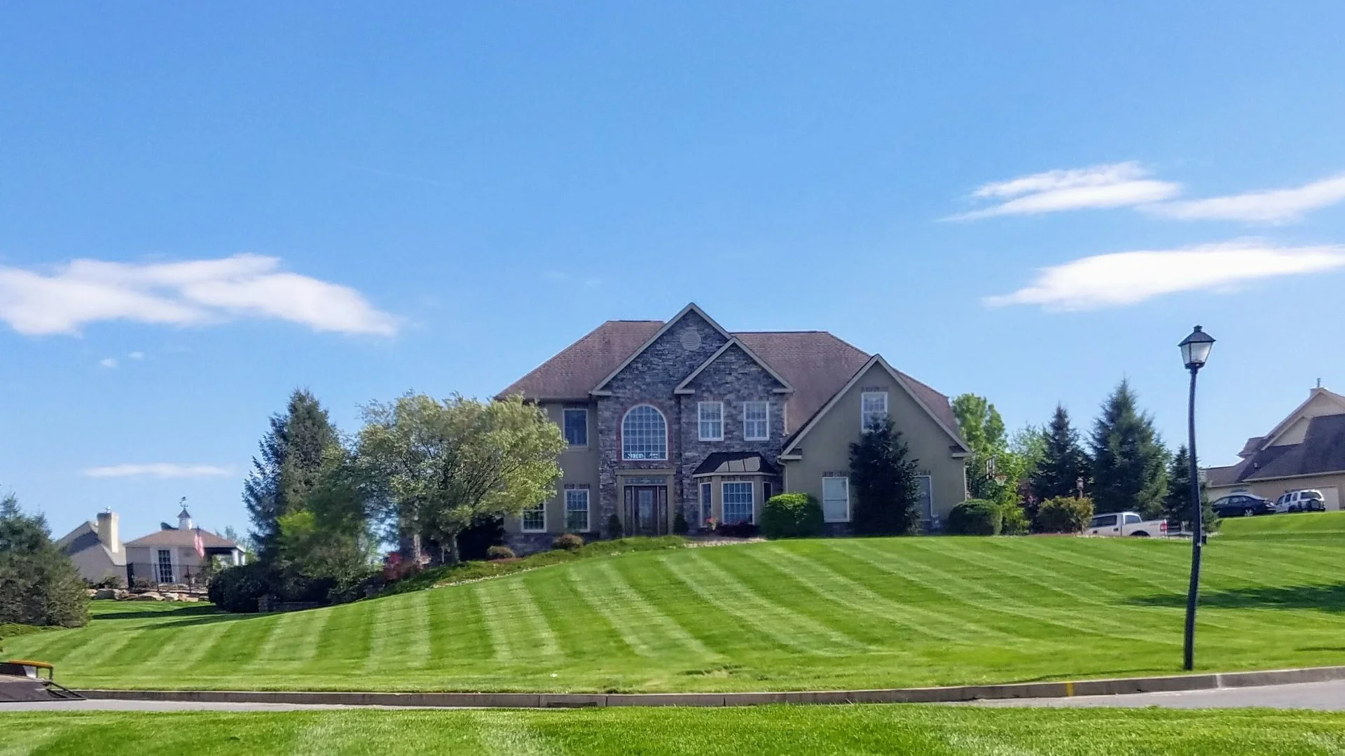 A beautiful house with a wide, lush green lawn, highlighting a well-maintained landscape in Fullerton, PA.