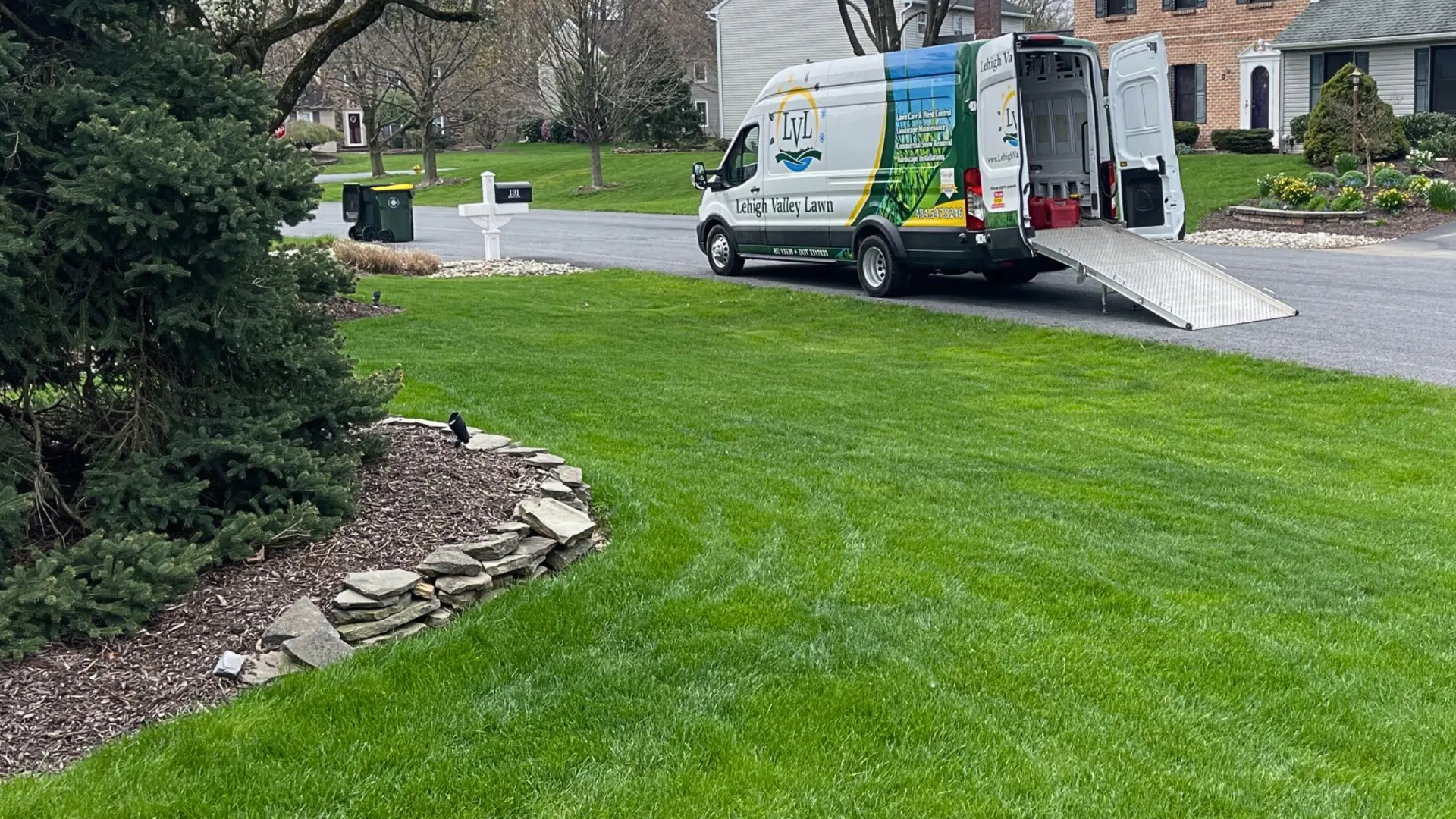 Work van parked in front of a home with a well-manicured lawn and beautiful landscaping inCatasauqua, PA.