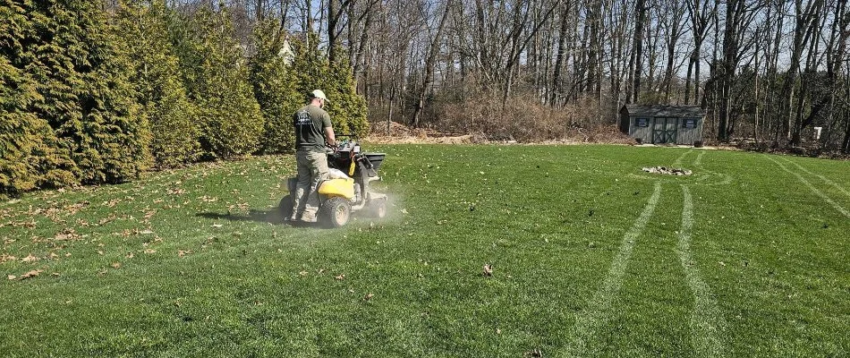 Crew spreading lawn care treatment on grass in Macungie, PA.