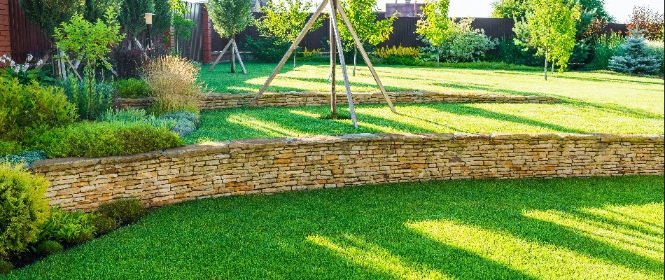 Retaining wall with grass and structures above it on a property in Northampton.