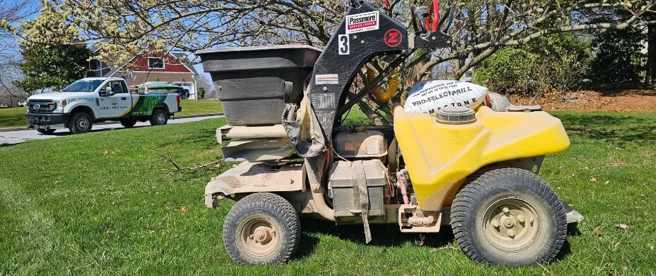 Granular fertilizer spreader on a lawn in Macungie, PA, and a company truck.