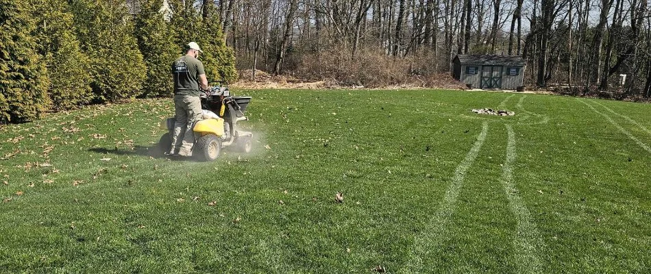 Crew applying fertilizer on green grass in Barto, PA.