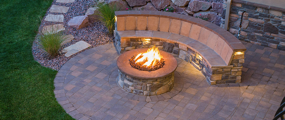 A birds eye view of a fire pit and custom seating wall in the evening at a home in Center Valley, PA. 