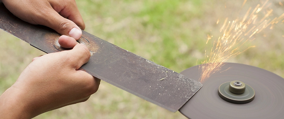 A professional sharpening a mower blade in Emmaus, PA.